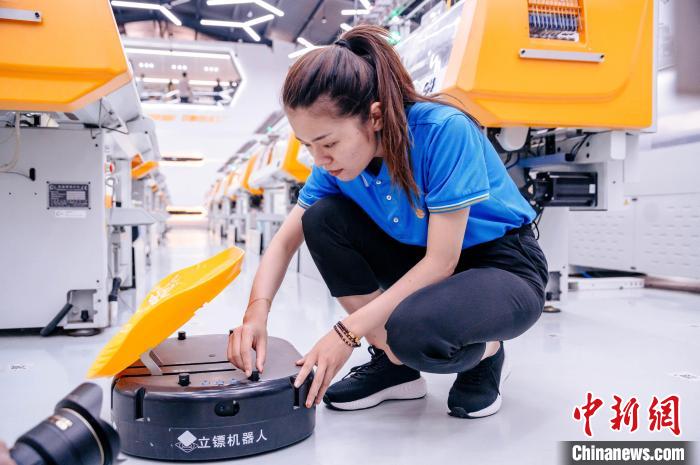 圖為員工在調(diào)試AGV搬運(yùn)機(jī)器人?！±钅宪?攝